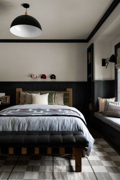 a bedroom with black and white checkered flooring, a large bed in the center