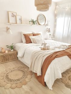 a bedroom with white walls and wooden flooring is decorated in neutral tones, such as beiges and browns