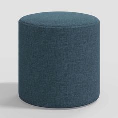 a blue round ottoman sitting on top of a white floor