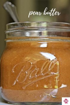 a glass jar filled with liquid sitting on top of a white counter next to a metal spoon