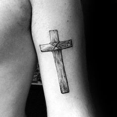 a cross tattoo on the left arm is shown in this black and white photo,