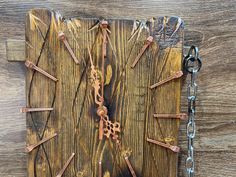 an old clock made out of wood with chains hanging from it's sides on a wooden surface