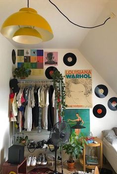 a room filled with lots of different types of clothes and records hanging on the wall