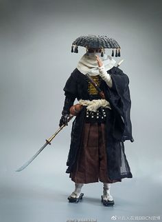 a doll is dressed in an old fashion outfit and holding a large umbrella over his head