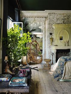 a living room filled with furniture and a fire place next to a brick fireplace covered in greenery