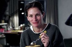 a woman sitting at a table with a spoon in her hand