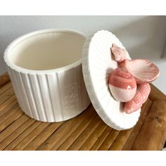 there is a white bowl with a pink flower in it on a wooden tray next to a cup