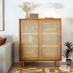 a living room with a couch and a cabinet in the corner next to a lamp