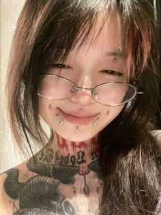 a girl with glasses and piercings on her neck