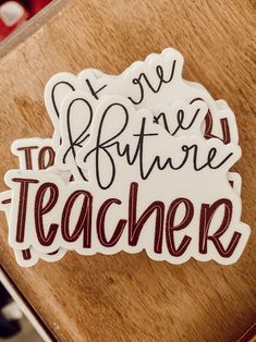 a wooden table topped with stickers that say teachers