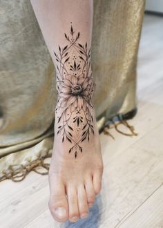 a woman's foot with a flower tattoo on it