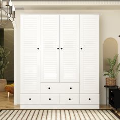 a large white closet with two doors and drawers next to a rug on the floor