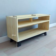 a wooden entertainment center with measurements for the top and bottom shelf, in front of a blue wall