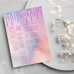 the wedding stationery is displayed on a plate next to some baby's breath flowers