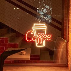 a neon sign that reads coffee in front of a window