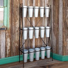 several white cups are stacked up on a shelf in front of a wooden paneled wall