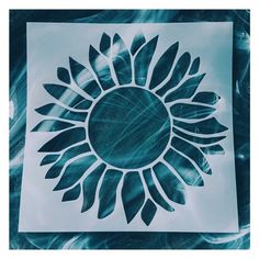 a paper cut out of a sunflower on top of blue and white marbled paper