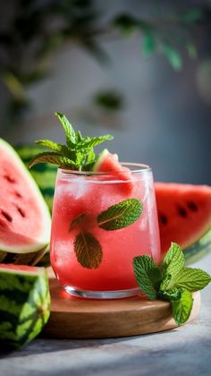 a watermelon drink with mint on the rim and slices of watermelon