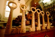 five wooden keys are lined up on a table in front of a man looking at them