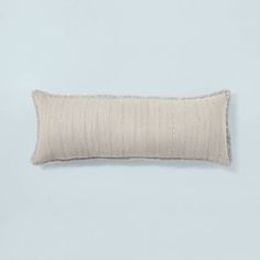 a white rectangular pillow on a light blue background