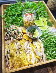 a wooden tray topped with lots of different types of food next to a jar of seasoning