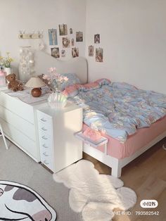 a bed room with a neatly made bed next to a white dresser and desk area