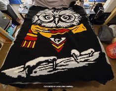 an owl knitted blanket sitting on top of a bed