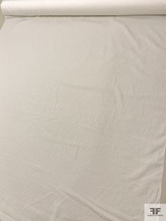 a white sheet that is laying on top of a bed