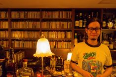 a man standing in front of a bar filled with liquor bottles