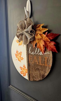 a door hanger decorated with fall leaves