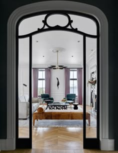 an open doorway leading to a living room with two chairs and a coffee table in it