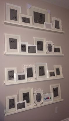 some white frames are hanging on the wall