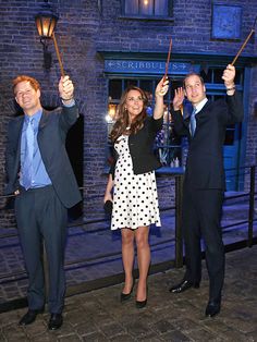 two men and a woman holding torches in front of a building