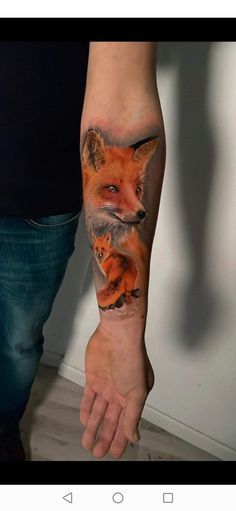 a man's arm with a fox tattoo on it