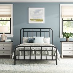 a bedroom with blue walls and white furniture