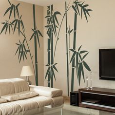 a living room with a television and wall decals on the walls that have bamboo trees painted on it