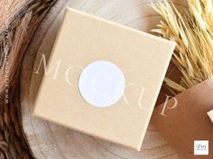 a cardboard box sitting on top of a wooden table next to some dried grass and a brown paper bag