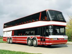 a red and white double decker bus parked on the street