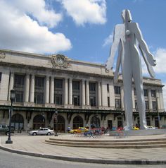 a large white statue in front of a building