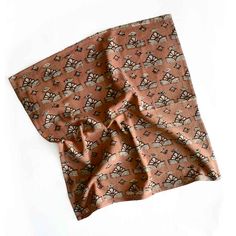 a piece of cloth on top of a white surface with an orange and brown pattern