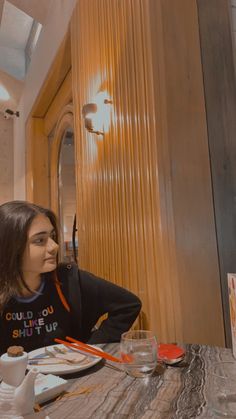 a woman sitting at a table with food in front of her