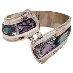 Sterling silver and abalone shell hinged bracelet from Mexico. A large and significant bracelet featuring beautiful abalone shell in a hinged bypass design. Weighs approx 62.0g, 39.9dwt Measures approx 7 1/4" on cone, 2 1/4" high at front, 3/4" high at back. Marked 925 MEXICO Very nice condition with slight surface scratching and light tarnish. Will come packaged in a gift box or pouch (when possible) and will be shipped US Priority Mail with insurance. CL011524/17KCS Bypass Jewelry, Mexican Jewelry, Hinged Bracelet, Abalone Shell, Dream Jewelry, Hinges, Insurance, Vintage Jewelry, Jewelry Bracelets