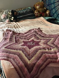 there is a crocheted blanket on the bed with teddy bears in the background