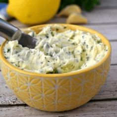 a yellow bowl filled with food on top of a wooden table