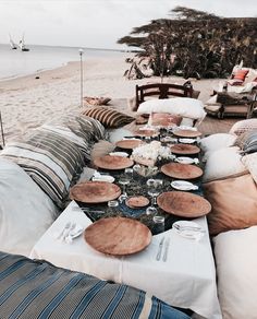 a table set up on the beach for an outdoor dinner