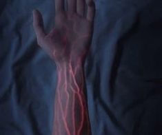 a person's hand is shown with red lightning streaks on their arm and wrist