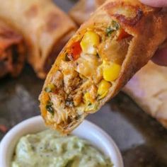 a close up of food on a stick with some dip in the bowl next to it