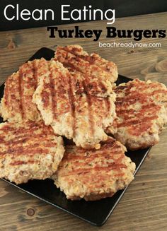 four turkey burgers on a black plate with the words turkey burgers above them