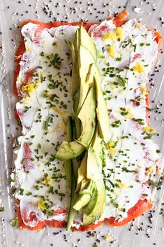 an avocado and sour cream pizza is on a plastic tray with sprinkles