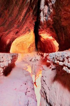 the water is running through the narrow slot in the rock formation, which looks like it's going to fall